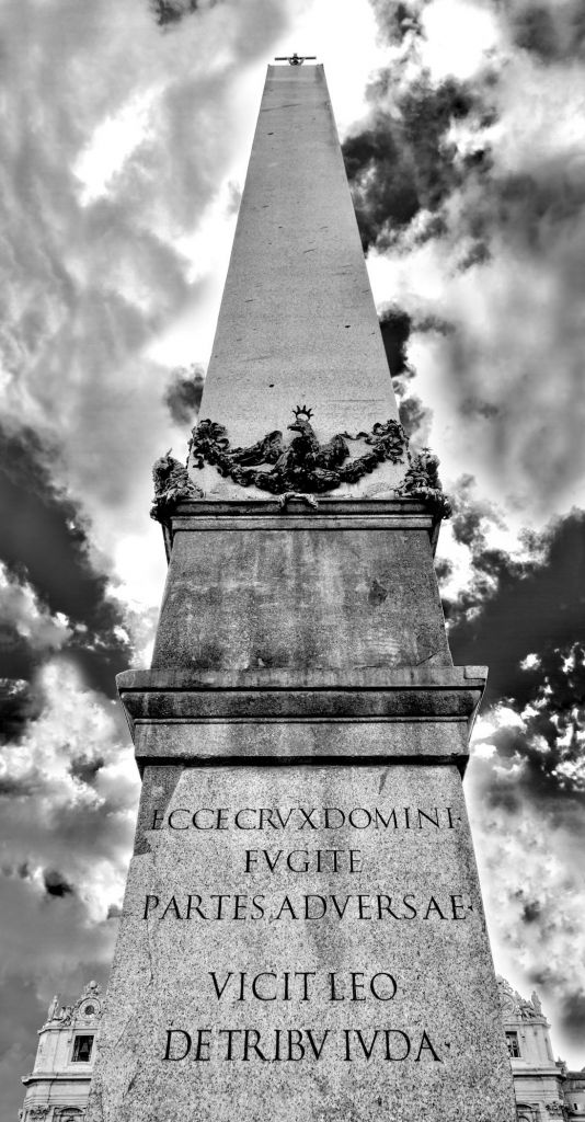 Obelisco in bianco e nero: prospettiva verticale tra pietra e nuvole