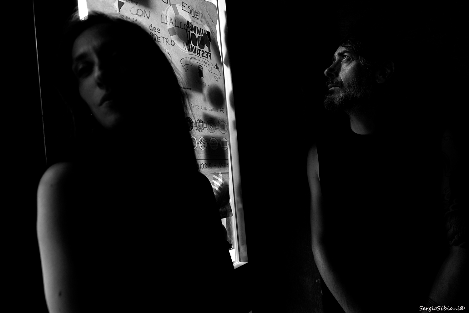 Distanze illuminate: volti in silhouette tra ombre e testo urbano