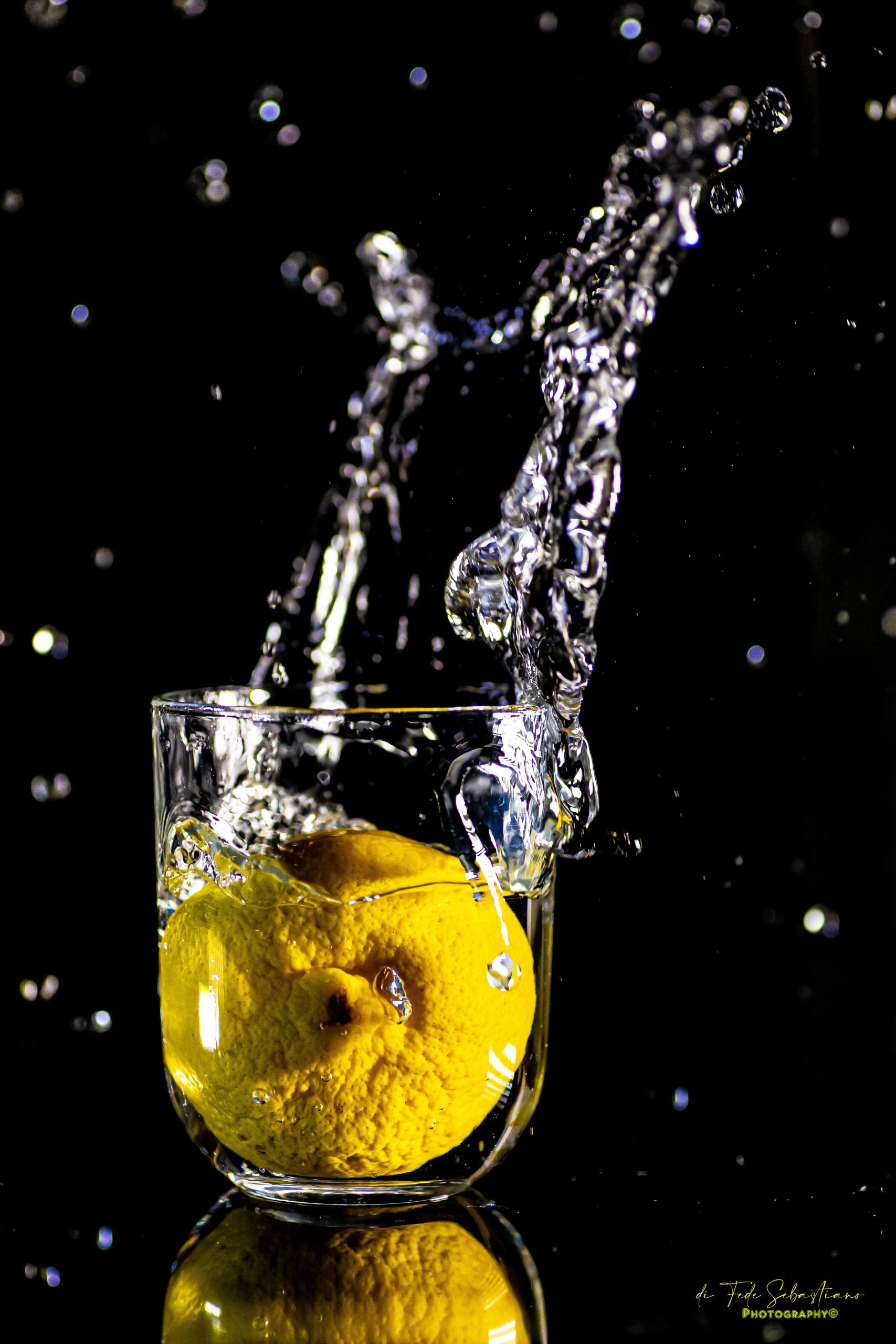 Fotografia Splash: limone nell’acqua tra schizzi, gocce e riflessi