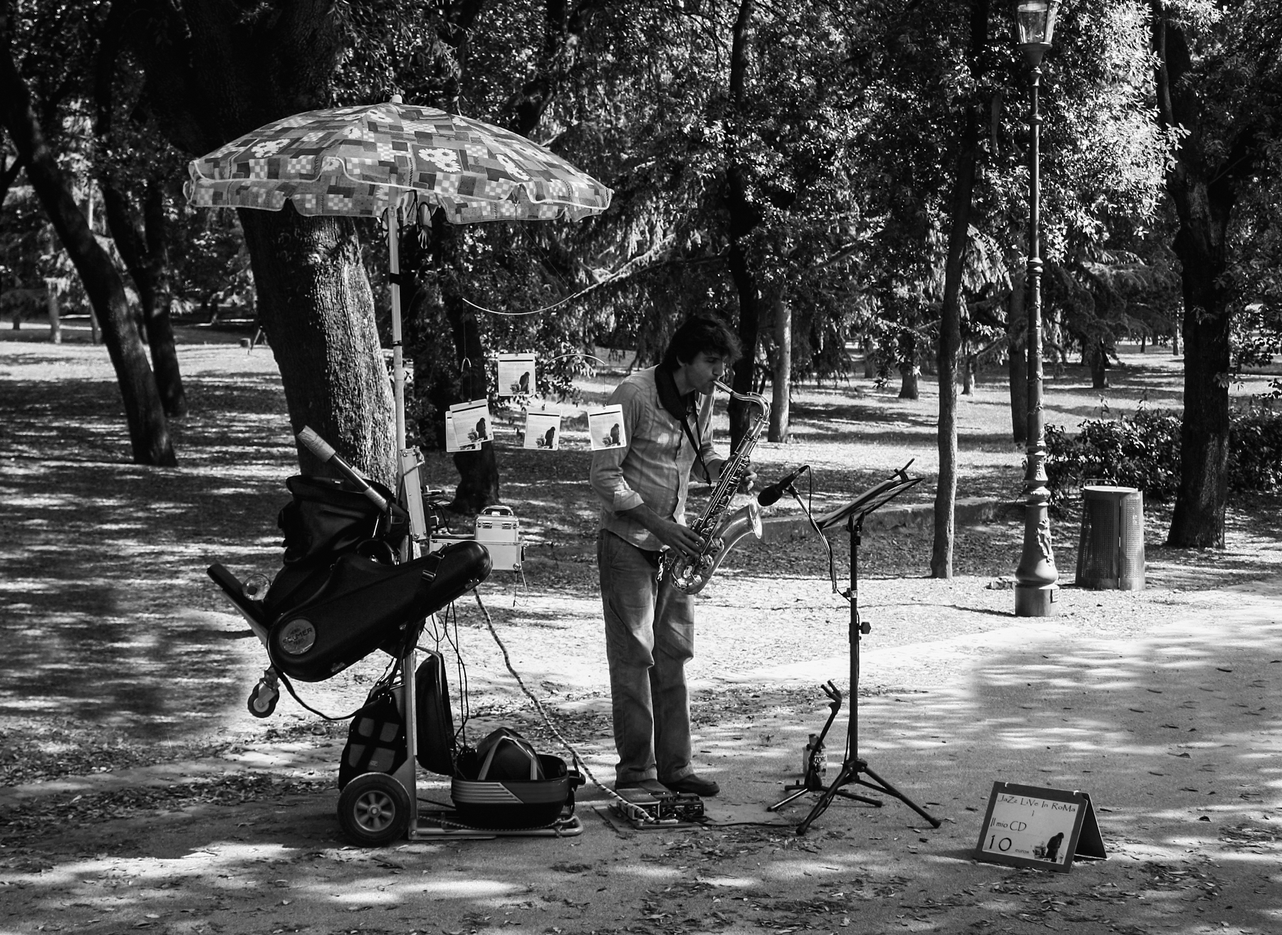 Suonatore di sax nel parco: scena documentaria in bianco e nero